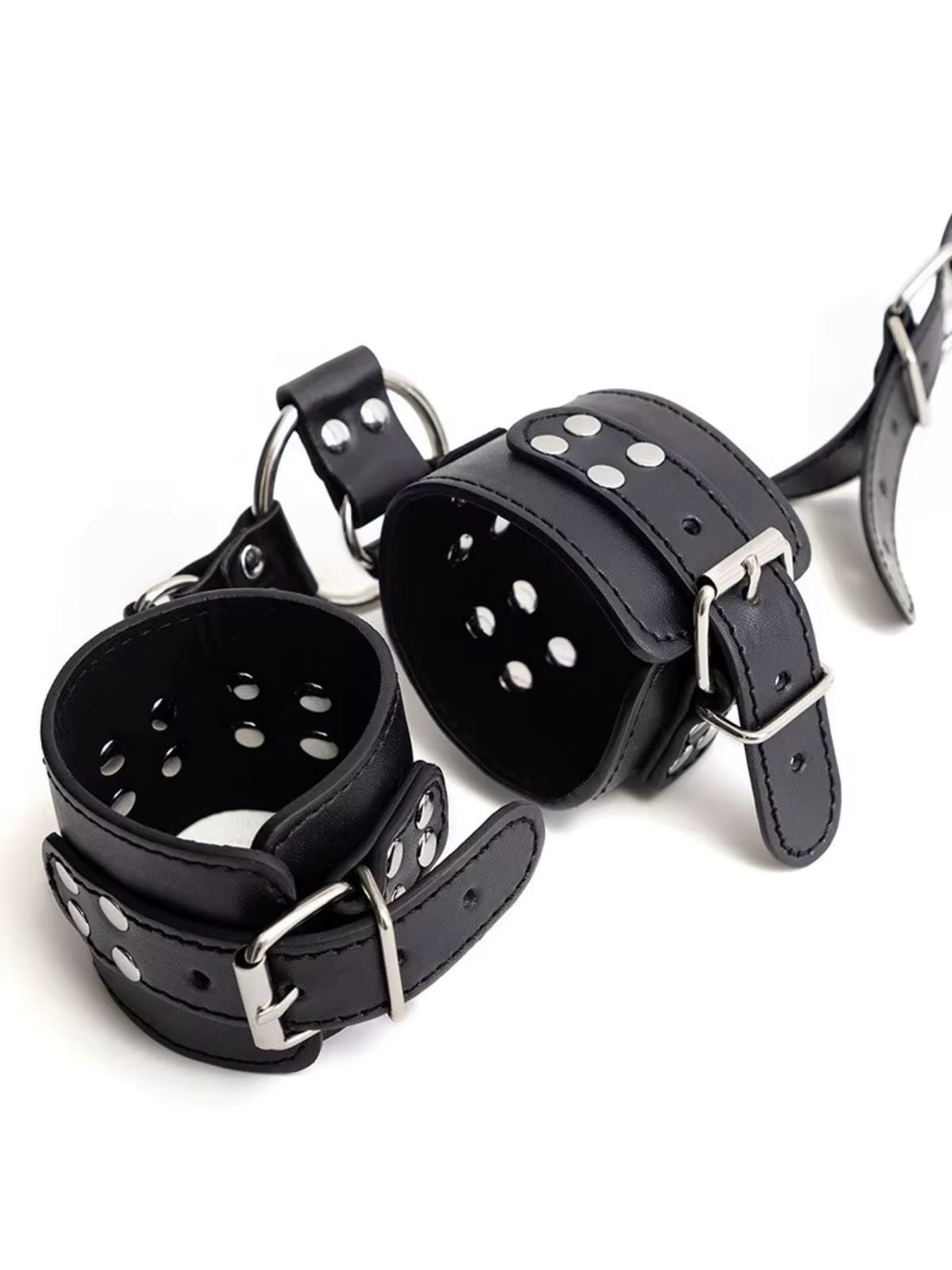 bdsm restraints black wrist cuffs close up with buckle straps and silver studs