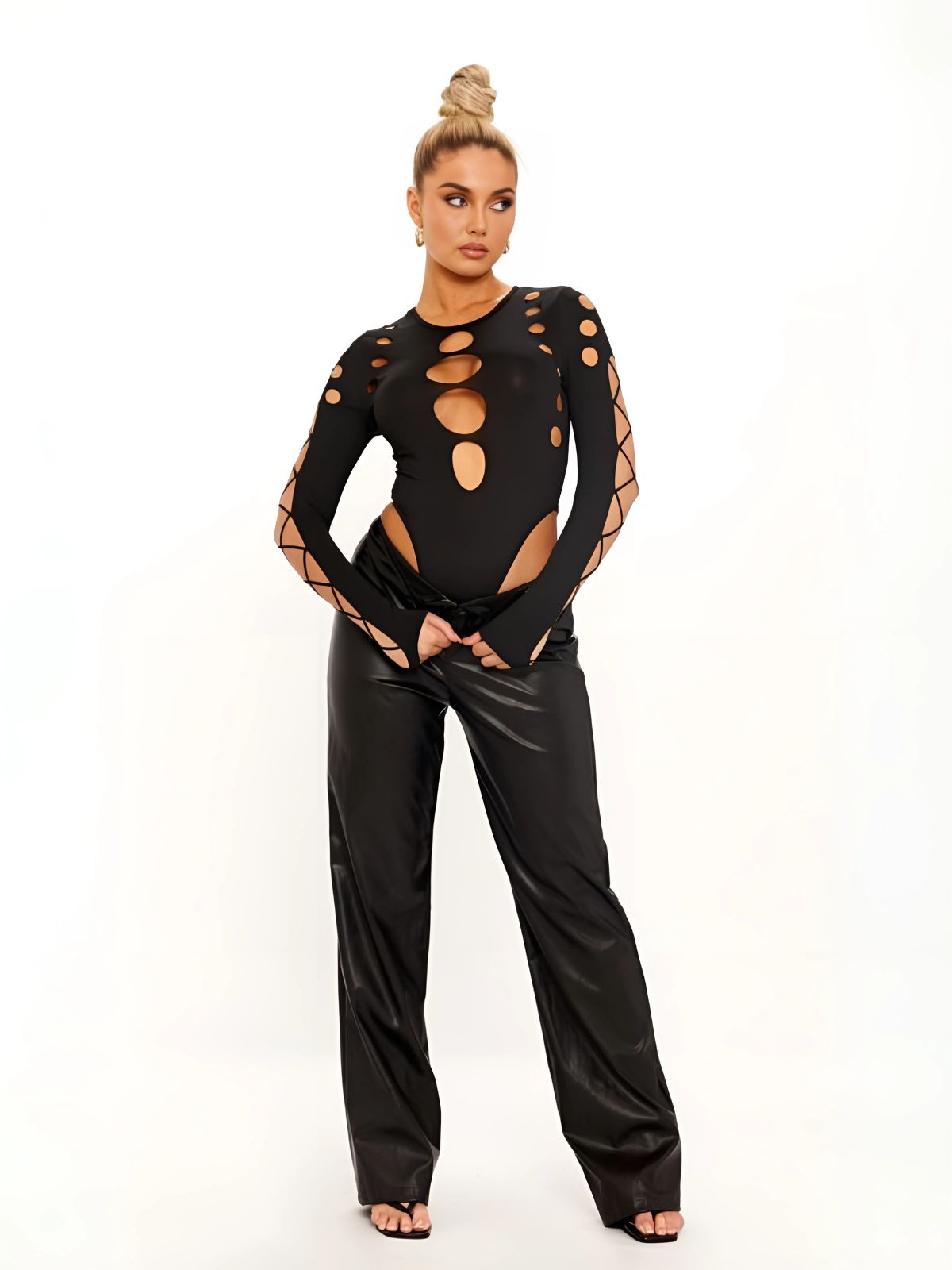Black cut out bodysuit paired with wide-leg leather pants, showcasing a bold and edgy outfit.