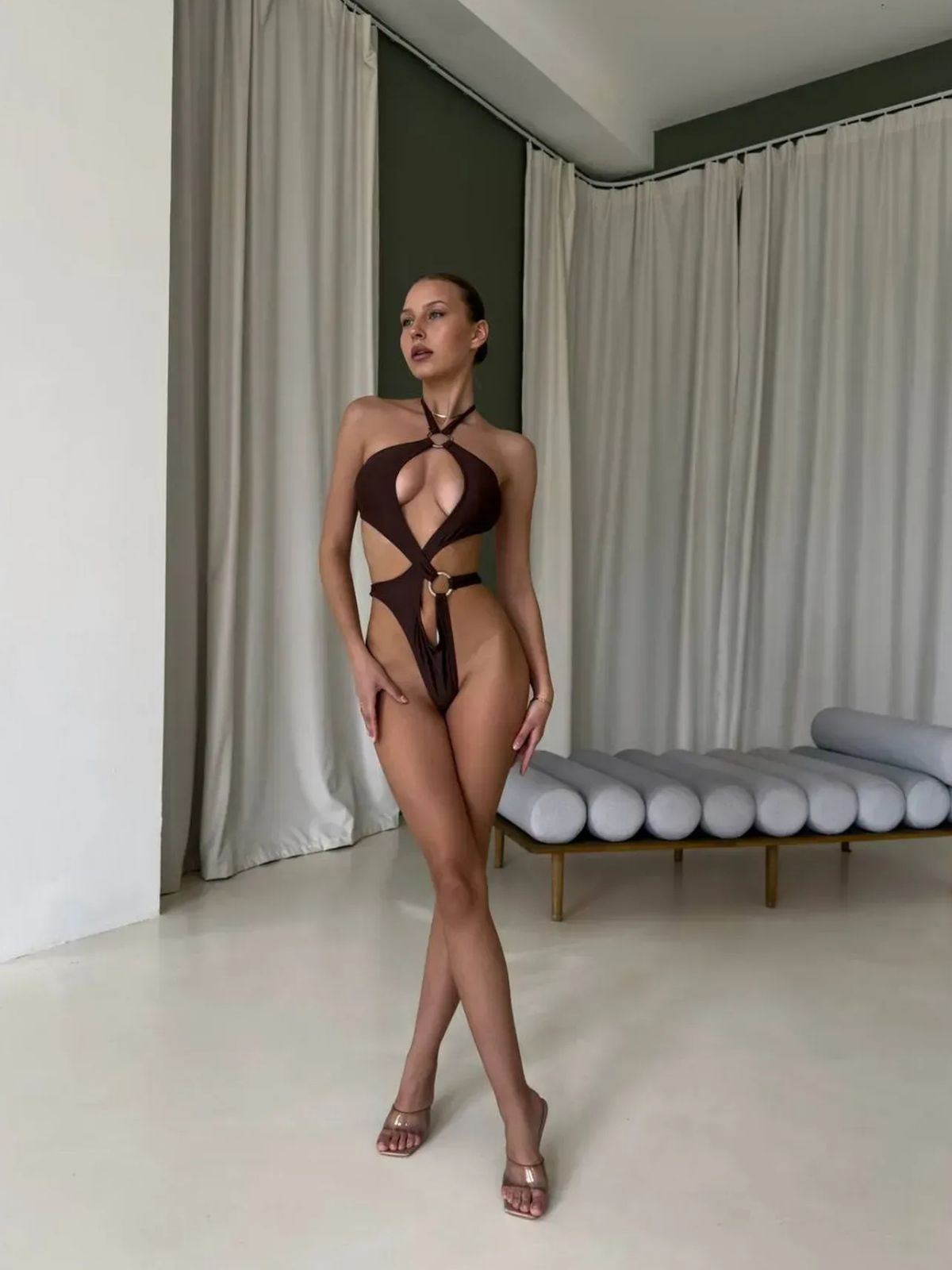 brown one piece swimsuit with o-ring cutouts, high-leg and halter neckline, full-body studio view