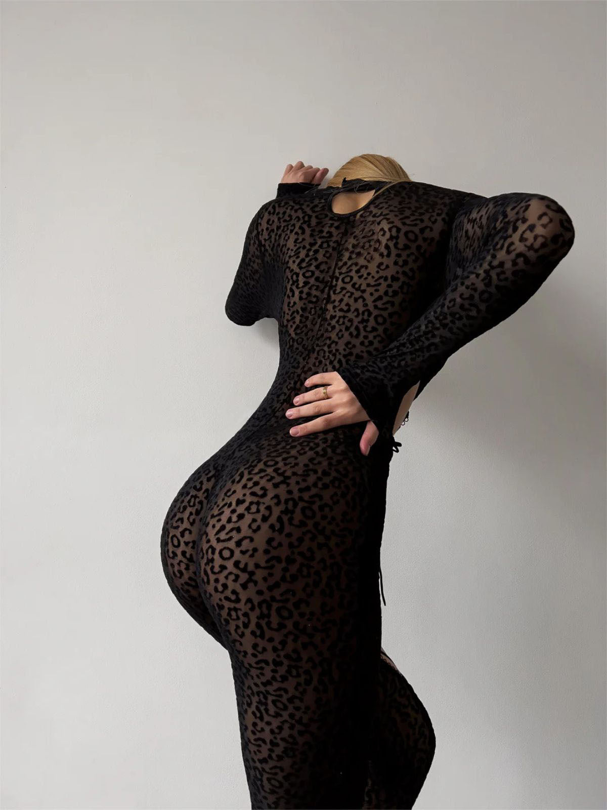 cutout bodysuit back view in sheer leopard mesh, fitted black silhouette