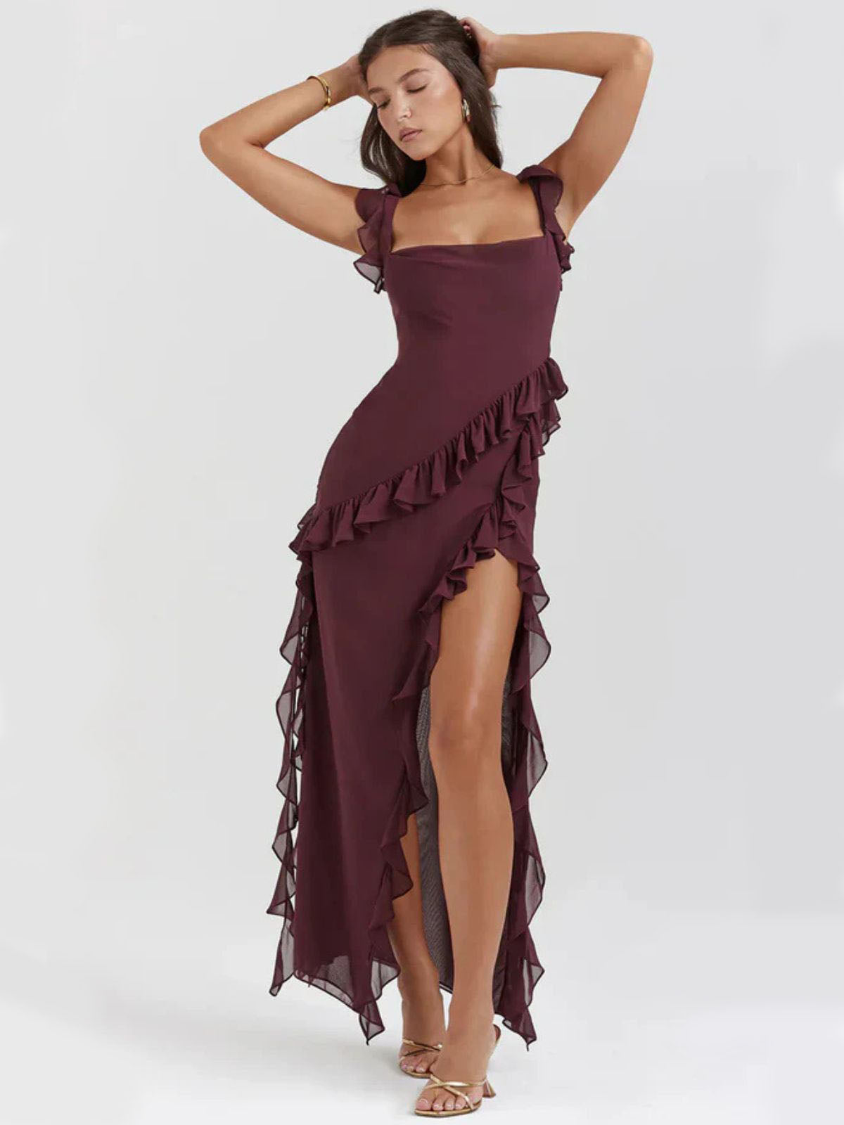 Elysian Ruffle Maxi - Brown model striking a dramatic pose, highlighting the asymmetrical ruffle accents and graceful drape.