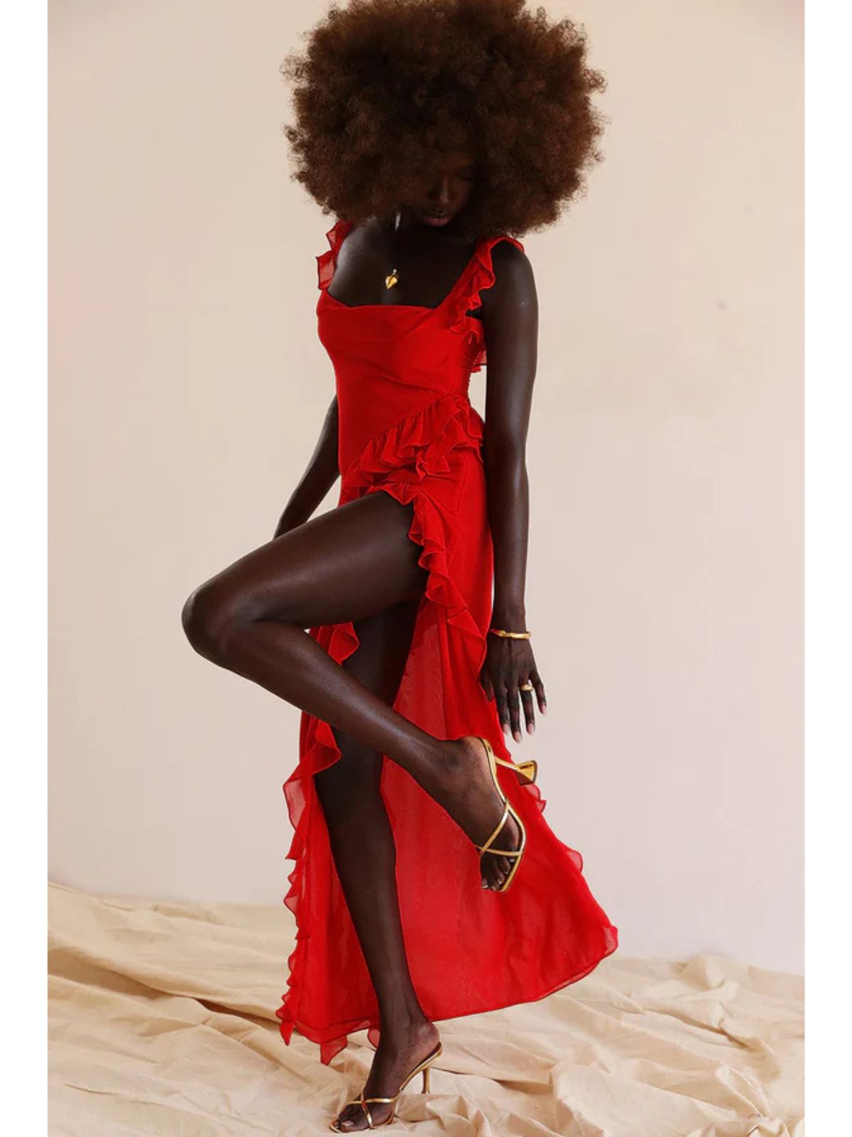 Elysian Ruffle Maxi - Red with a model in motion, emphasizing the high slit, asymmetrical hem, and luxurious fabric flow.