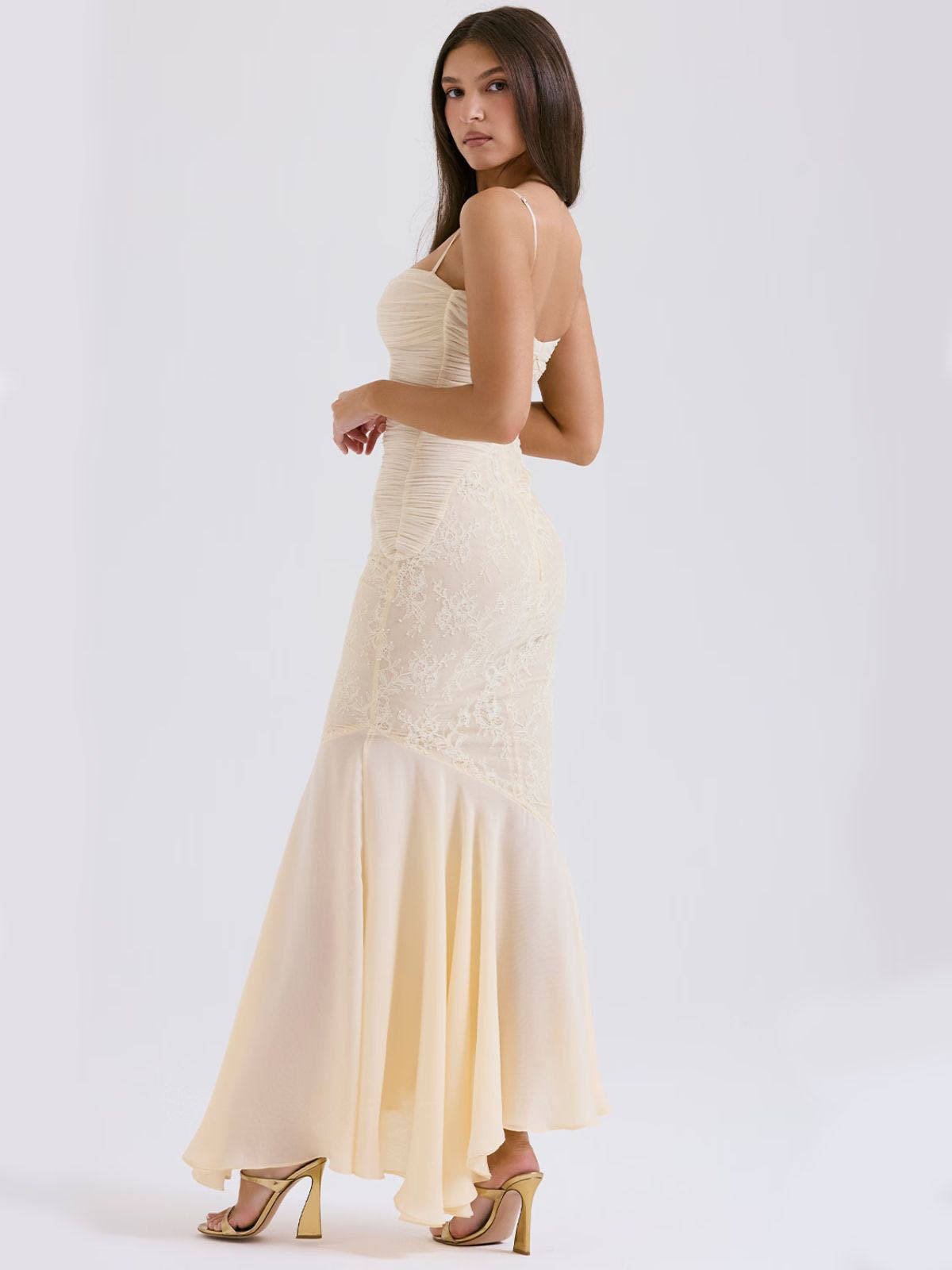 Ivory Grace Lace Gown – floral lace maxi dress featuring a lace bodice, mid-waist fit, and a flowing skirt in an angled pose.