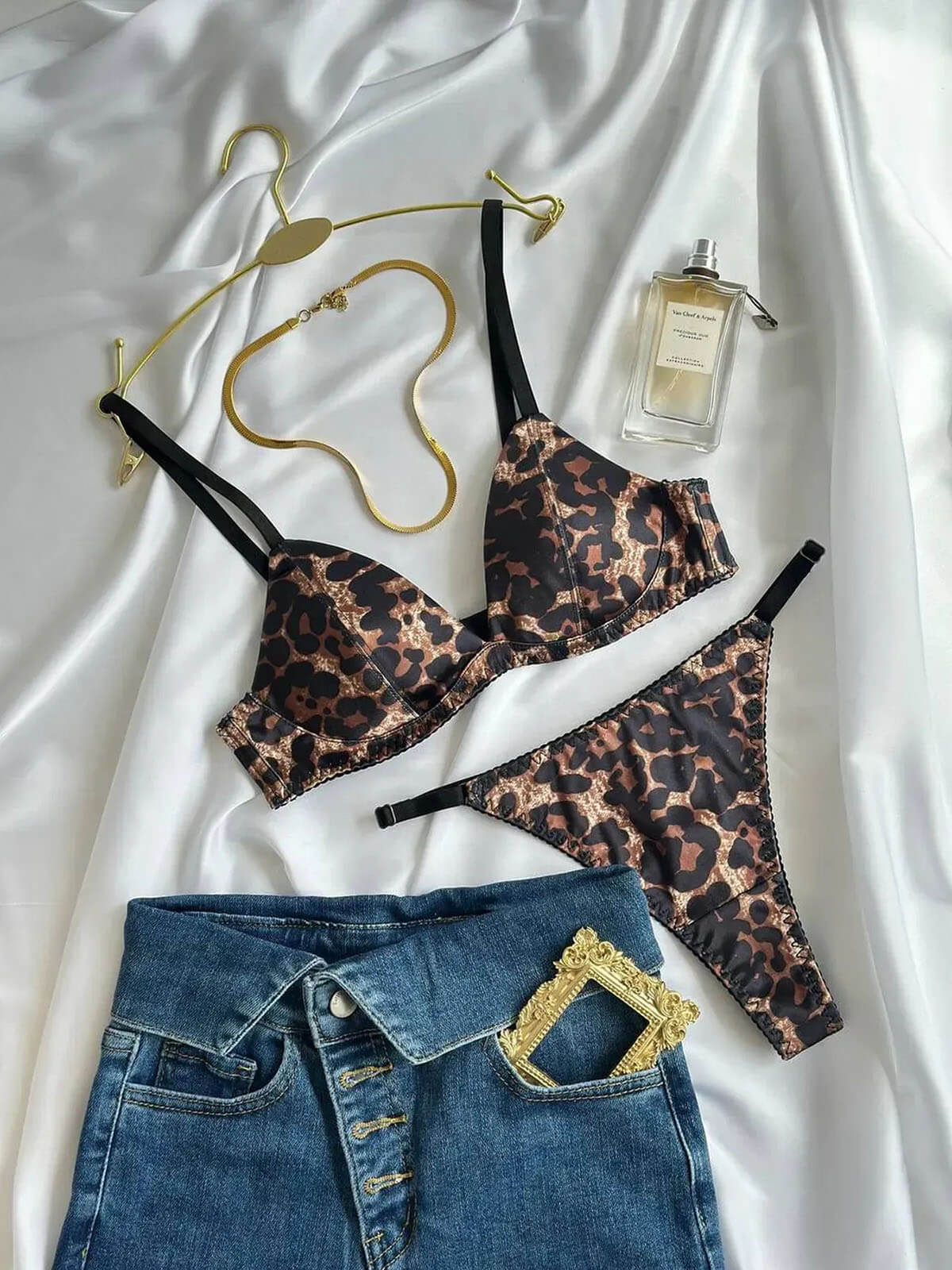 Leopard Print Lingerie Pushup bra and thong flat lay on satin with jeans, gold accessories and perfume