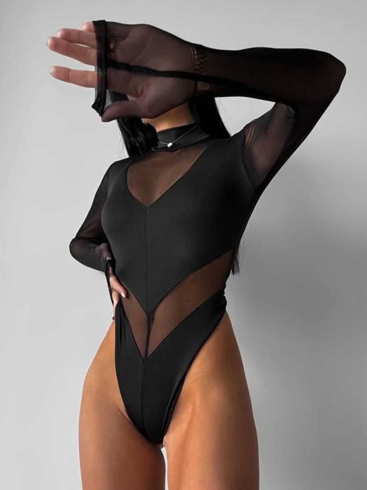 Obsidian Luxe Sheer Bodysuit front view with mesh stitching, long sleeves, and a chic high-waist design.
