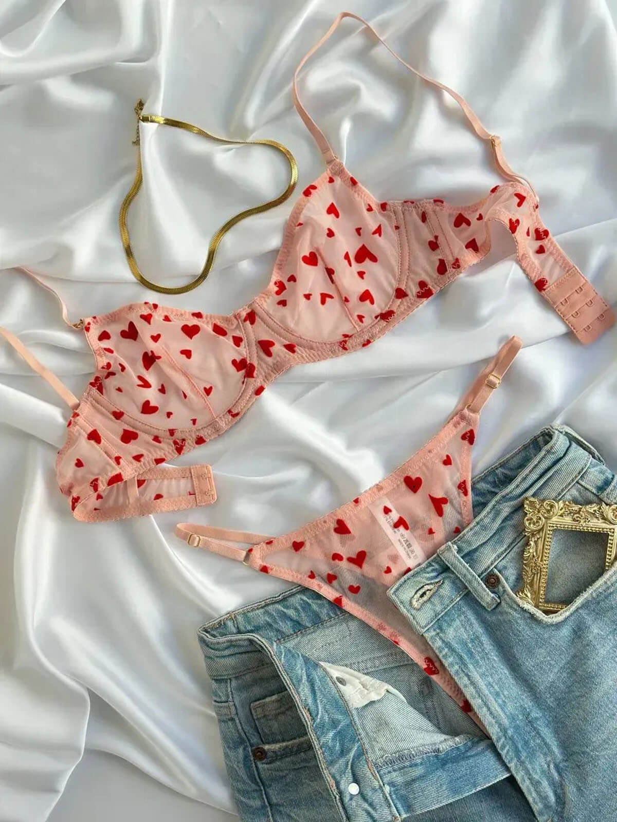 Pink Heart Lingerie set flat lay with sheer bra and thong on satin background