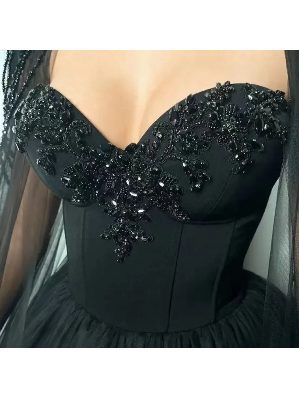 Raven Noir Embellished Wedding Gown featuring intricate beaded details on the front bodice and elegant neckline.