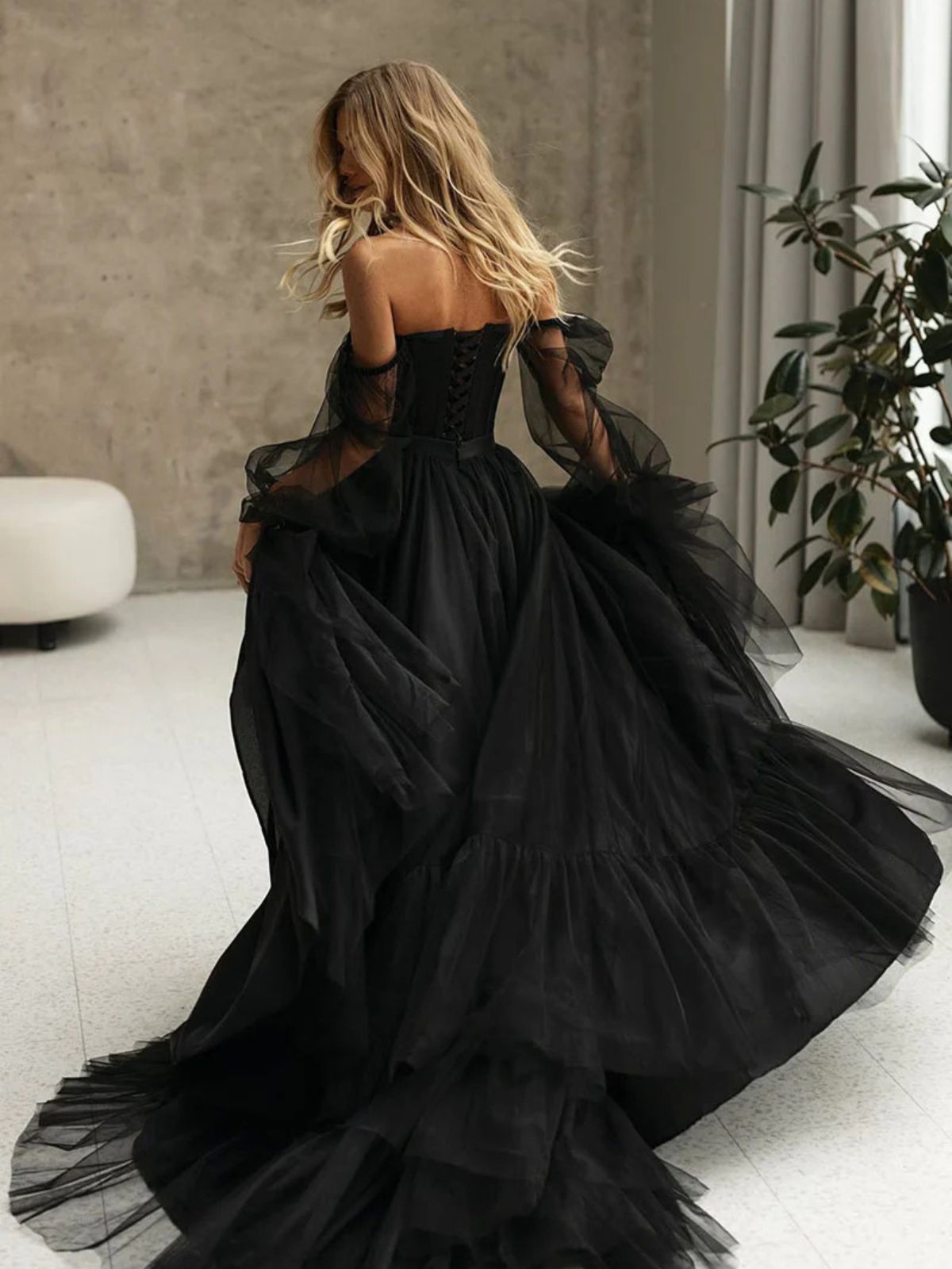 Close-up of romantic tulle black wedding gown with sheer sleeves and detailed craftsmanship