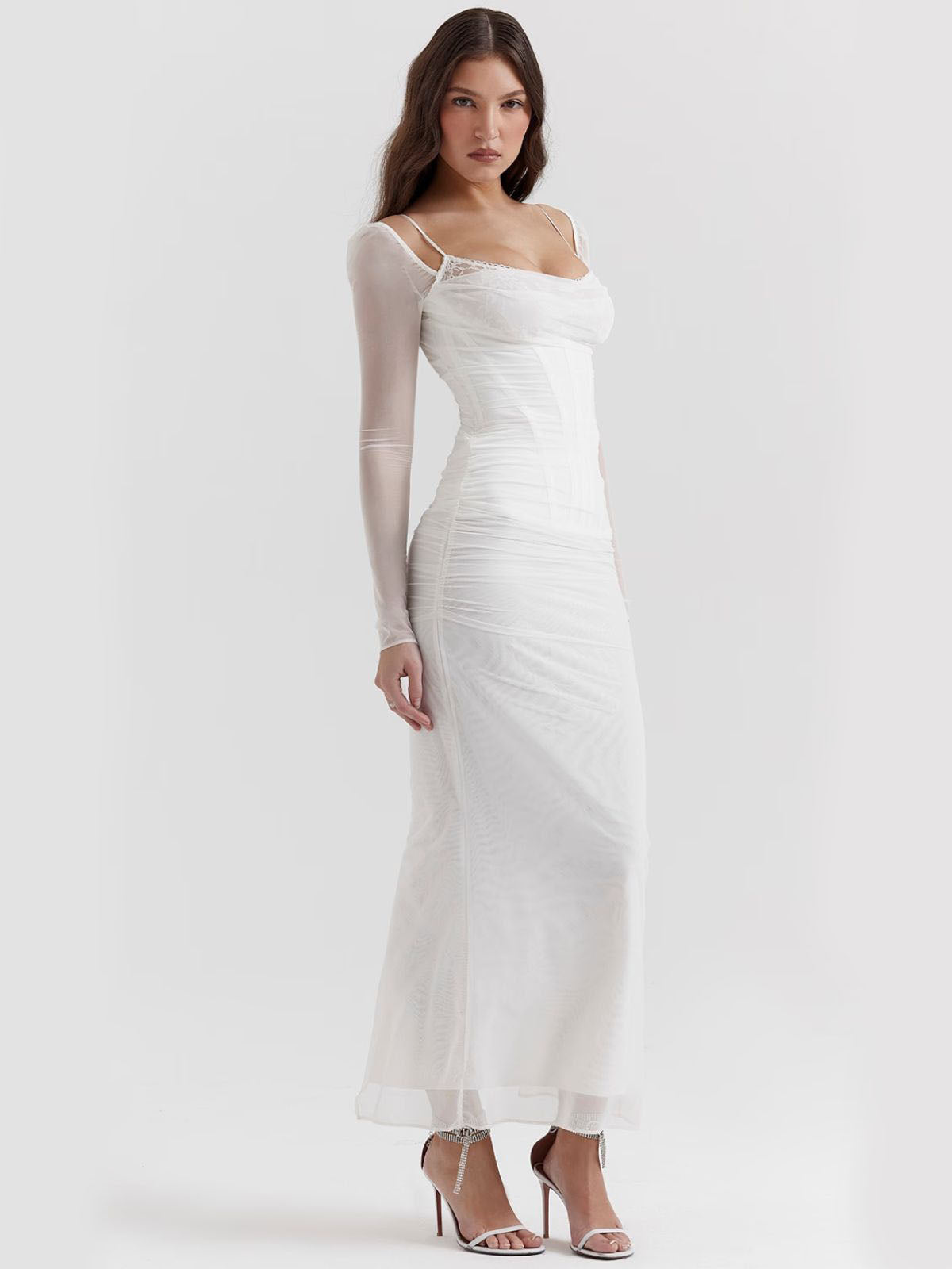 White lace maxi dress with delicate lace details and sheer long sleeves, perfect for formal events.
